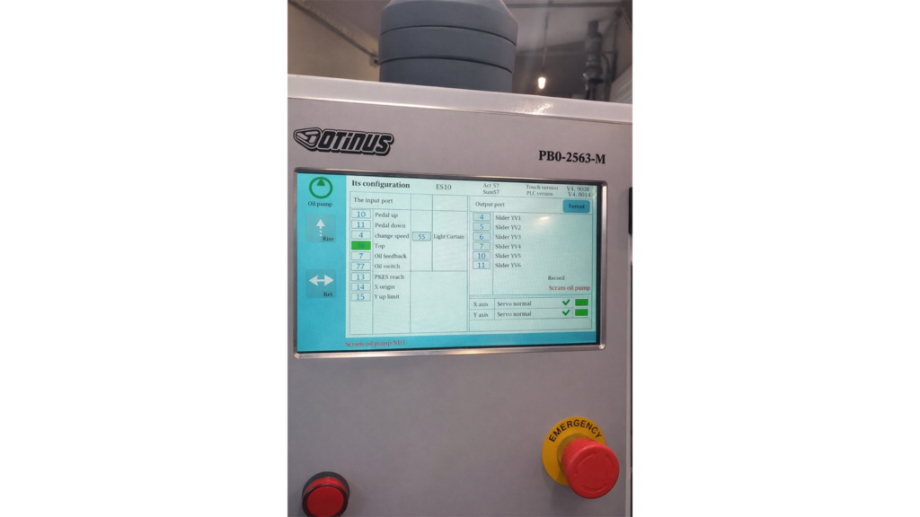 Panel sterowania Delem DA-58T w prasie krawędziowej Otinus, prezentujący ekran konfiguracji wejść i wyjść, status osi serwo, układ hydrauliczny oraz przycisk awaryjny w profesjonalnym środowisku przemysłowym.