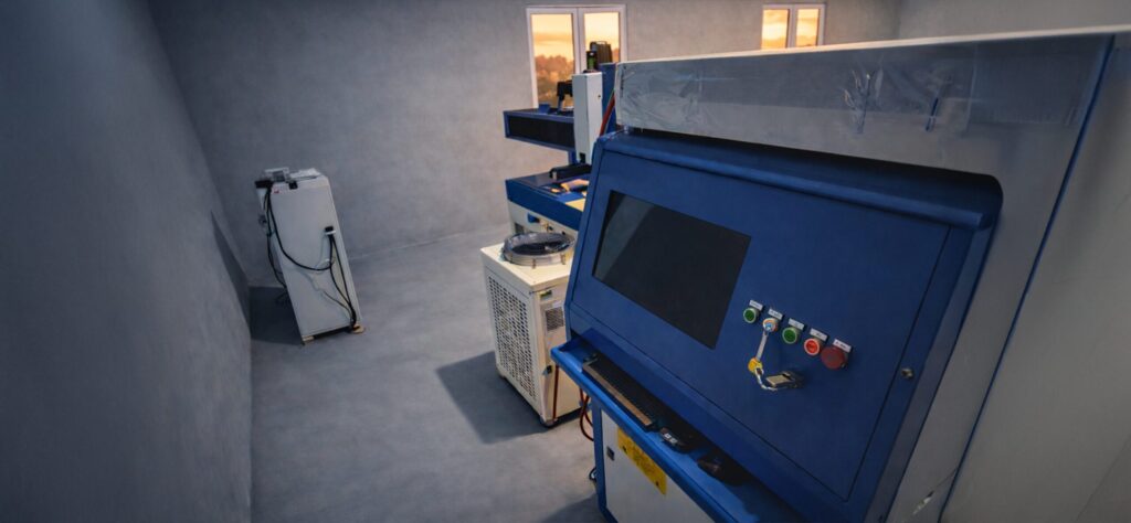 Stanowisko wycinarki laserowej Otinus z otwartą obudową i panelem sterowania CNC, przygotowane do precyzyjnej obróbki metalu w kontrolowanych warunkach produkcyjnych.