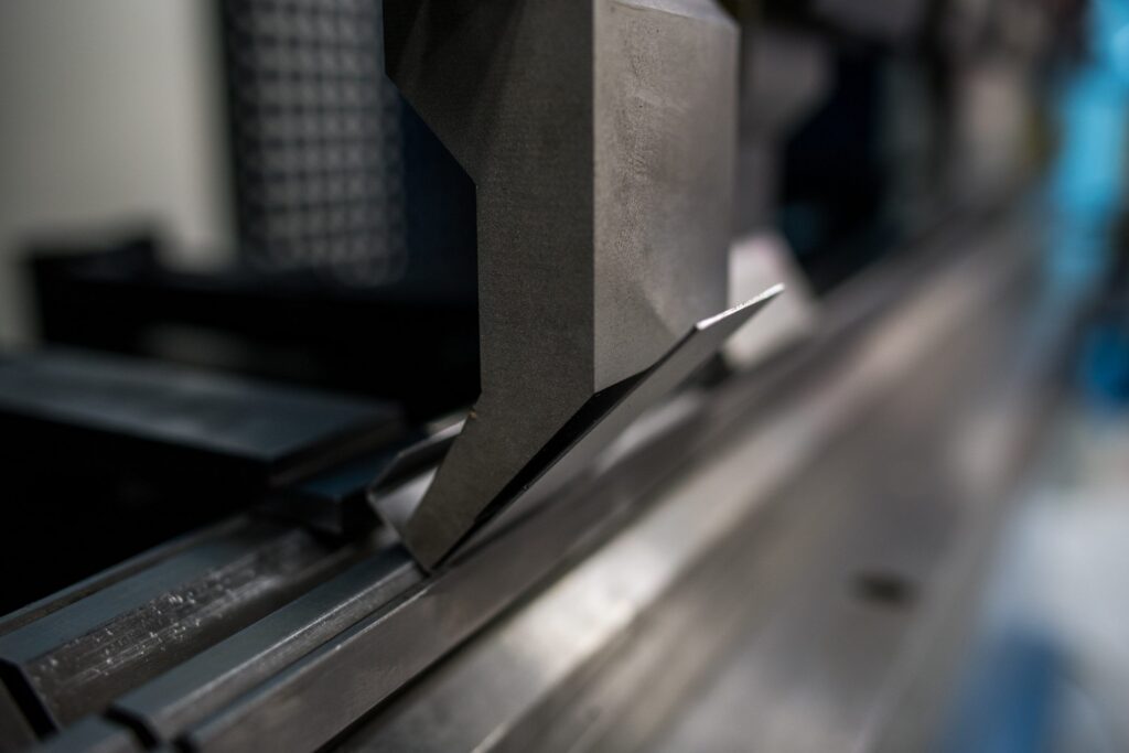 Close-up of a precision press brake punch positioned over the die, ready for accurate sheet metal bending. The hardened tooling ensures clean bends, high repeatability, and reliable performance in industrial production.