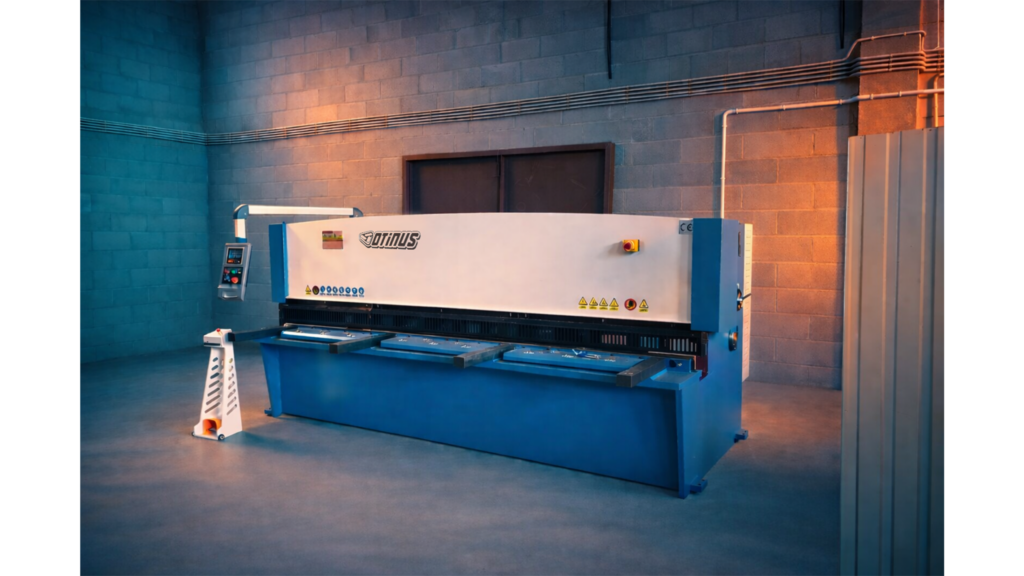 Otinus Base guillotine shear in a modern production hall, highlighting its heavy-duty construction, intuitive control panel, and stable working table designed for precise sheet metal cutting.