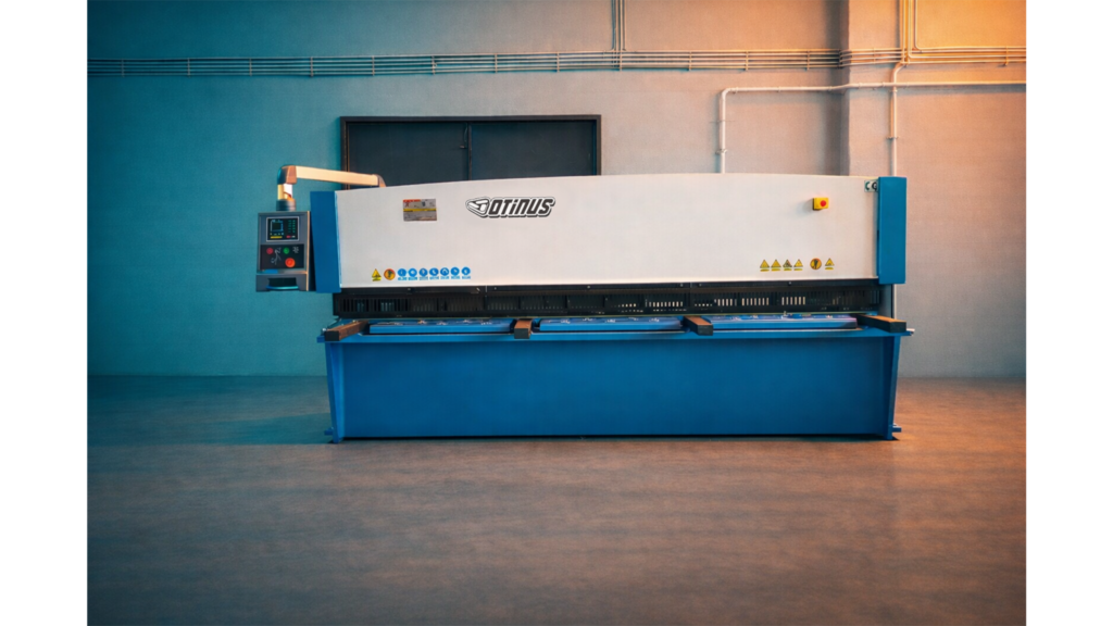 Front view of the Otinus Base guillotine shear in an industrial hall, emphasizing its symmetrical, solid construction, precise cutting mechanism, and clearly arranged control panel designed for efficient operation.