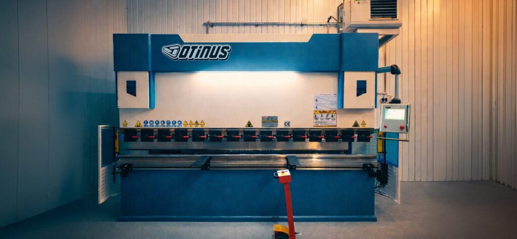 An Otinus press brake equipped with the Delem DA-58T control system, installed in a modern production hall, highlighting precision bending, advanced CNC control, and industrial-grade build quality.