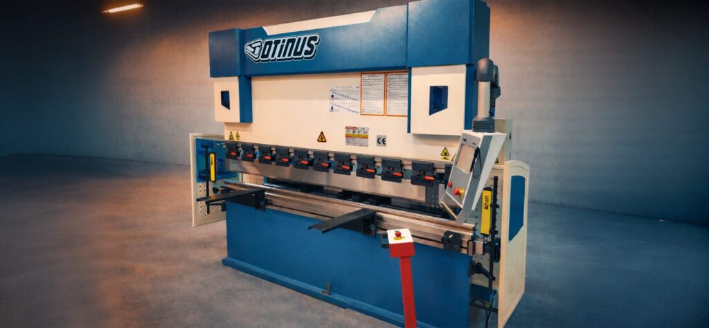 Industrial Otinus press brake with the Delem DA-58T control system, shown from a side perspective, designed for precise sheet metal bending in a modern and spacious production hall.